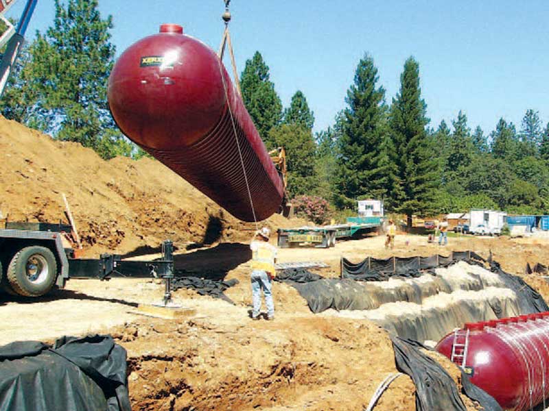 A crane lifts a Xerxes wastewater treatment tank into position